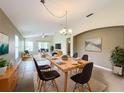 Open-concept dining room featuring a light wood table with seating for six and seamless flow into the living area at 167 Bell Tower Xing W, Poinciana, FL 34759