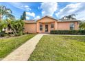 Inviting single-story home featuring well-maintained lawn, landscaping, and a brick walkway leading to the front entrance at 167 Bell Tower Xing W, Poinciana, FL 34759