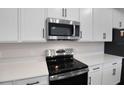 Stainless steel appliances and white cabinetry in the kitchen at 2918 Sharp Rd, Kissimmee, FL 34744
