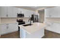 Modern kitchen with white cabinets, island, and stainless steel appliances at 2918 Sharp Rd, Kissimmee, FL 34744