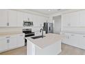 Modern kitchen featuring white cabinets, stainless steel appliances, and a center island at 922 Heirloom Dr, Haines City, FL 33844