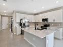 Modern kitchen features stainless steel appliances and an island with white cabinets at 1446 Maddie Berry Ln, Kissimmee, FL 34744