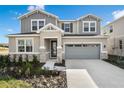 Two-story house with gray siding, stone accents, and a two-car garage at 883 Griffon Ave, Lake Alfred, FL 33850