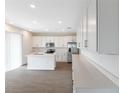 Bright kitchen featuring white cabinets, an island, and stainless steel appliances at 883 Griffon Ave, Lake Alfred, FL 33850