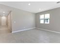 Bright, neutral living room showcasing tile floors, natural light from the window, and smooth walls at 4220 Sawtooth Ct, Tavares, FL 32778