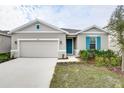 Curb appeal of a one-story house featuring gray siding and teal accents at 1634 Sugarbelle Cir, Mascotte, FL 34753