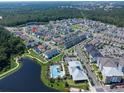 Community aerial view showcasing a pool, walking trails, and numerous homes situated amongst green spaces and a lake at 1862 Beach Ridge Rd, Celebration, FL 34747