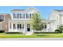 Beautiful two-story home with a wide front porch, black shutters, and a well-manicured lawn at 1862 Beach Ridge Rd, Celebration, FL 34747