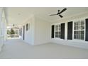 Inviting covered porch with ceiling fans and classic white columns, offering a relaxing outdoor space at 1862 Beach Ridge Rd, Celebration, FL 34747