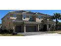 Beautiful tan two-story home with a two-car garage, a tiled roof, a driveway, and a palm tree at 3801 Sonoma Blvd, Kissimmee, FL 34741