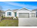 Charming single-story home with a well-manicured lawn, gray garage door, and a welcoming blue front door at 2015 Stetson Ct, Eagle Lake, FL 33839