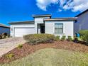 Charming one-story home featuring a brick driveway, two-car garage, and well-maintained landscaping at 185 Brookes Pl, Haines City, FL 33844