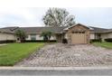 Charming home featuring a brick driveway, stone accents on the garage, and a manicured lawn at 2724 Shelby Ruth Pl, Saint Cloud, FL 34769