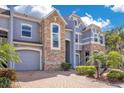 A close view of the townhome's well-maintained brick driveways, front yard landscaping and stone facade at 2106 Chatham Place Dr, Orlando, FL 32824