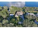Stunning aerial view of a lakeside home nestled among mature trees, showcasing its privacy and scenic location at 19529 Dorr Rd, Altoona, FL 32702