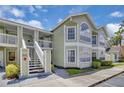 Charming two-story condo with staircase access, showcasing its inviting facade and landscaping at 3145 Britannia Blvd # D, Kissimmee, FL 34747