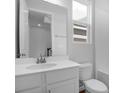 Clean bathroom features a white vanity with mirror and white tile walls with natural light at 1647 Sugarbelle Cir, Mascotte, FL 34753