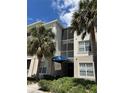 A condo building with a blue awning and palm trees in front of the building at 3301 Whitestone Cir # 308, Kissimmee, FL 34741