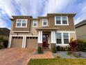 Charming two-story home with a two-car garage, brick drive, and lush front lawn at 8118 Platts Ave, Orlando, FL 32832