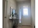 Bright foyer with a decorative mirror, console table, and tiled flooring at 8118 Platts Ave, Orlando, FL 32832
