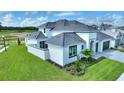 Two-story home with gray roof, white exterior, and landscaped lawn at 107 Hampton Loop, Davenport, FL 33837