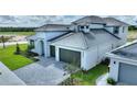 Two-story home with gray roof, white exterior, two-car garage, and landscaped lawn at 107 Hampton Loop, Davenport, FL 33837