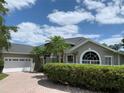 Attractive exterior view showcasing the home's architectural details, two-car garage, and paved driveway at 14421 Hatchee Ct, Orlando, FL 32837