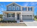 Inviting two-story home showcases a covered front porch, two-car garage, and well-maintained landscaping at 500 Summit River Dr, Apopka, FL 32712