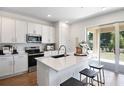 Bright, modern kitchen with white cabinets, stainless steel appliances, a large island, and sliding door access at 500 Summit River Dr, Apopka, FL 32712