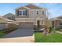 Charming two-story home showcasing a manicured lawn and a neutral color scheme with stone accents at 199 Bull Frog Ln, Umatilla, FL 32784