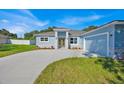 Charming single-story home with a well-manicured lawn and a light blue exterior and stone accents at 319 Water Shore Dr, Leesburg, FL 34748