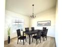 Formal dining room with modern chandelier, a large window and seating for six at 1928 Drum Dr, Kissimmee, FL 34759