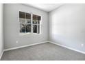 Bright bedroom with gray walls and carpeting, featuring a large window at 4200 Sawtooth Ct, Tavares, FL 32778
