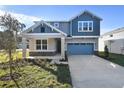 Two-story house with gray siding, stone accents, and a two-car garage at 4200 Sawtooth Ct, Tavares, FL 32778