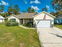 Inviting single-Gathering home featuring an attached garage, neat landscaping, and an American flag on display at 2909 Annalee Rd, Saint Cloud, FL 34771