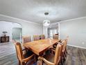 Dining room with a large wooden table, eight chairs, and a modern light fixture at 32122 Hickory Ln, Sorrento, FL 32776