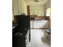 Kitchen with white cabinets and appliances at 4910 Huppel Ave, Orlando, FL 32811