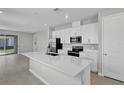 Modern kitchen with stainless steel appliances, white cabinets, and a large center island at 203 Bull Frog Ln, Umatilla, FL 32784