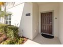 Welcoming front door with a modern address plaque, surrounded by neat landscaping at 4891 Clock Tower Dr, Kissimmee, FL 34746