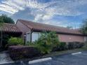 Charming home exterior with a red tiled roof, lush landscaping, and designated parking spots at 618 Saint Johns Ct, Winter Park, FL 32792