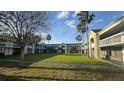 Exterior view of the property featuring a central lawn, palm trees, and walkways at 5245 W Irlo Bronson Memorial Hwy # 160, Kissimmee, FL 34746