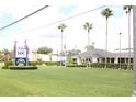 A charming building with lush green grass, manicured hedges, and multiple tall palm trees, offers a welcoming and serene environment at 5245 W Irlo Bronson Memorial Hwy # 160, Kissimmee, FL 34746