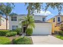 Two-story home featuring a two-car garage, manicured landscaping, and a covered front entry at 121 Madiera Beach Blvd, Kissimmee, FL 34746