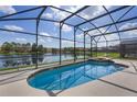 Screened-in pool and spa overlooking a tranquil lake, perfect for relaxation and outdoor enjoyment at 121 Madiera Beach Blvd, Kissimmee, FL 34746