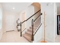 Bright entryway featuring a staircase with dark wood railings and neutral tile flooring at 1853 Summer Serenity Dr, Kissimmee, FL 34744