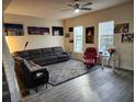 A cozy living room with a grey rug, a reclining sofa, and plenty of natural light from the window at 319 Celebration Blvd, Celebration, FL 34747