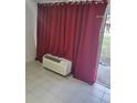 Living room with red curtains and an air conditioning unit at 7900 S Orange Blossom Trl # 1120, Orlando, FL 32809