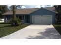 Exterior view of home with a two car garage and blue paint at 106 Sparrow Ct, Kissimmee, FL 34759