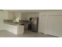Bright kitchen featuring white cabinets, stainless steel appliances, and an island with bar seating at 106 Sparrow Ct, Kissimmee, FL 34759