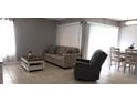 Bright living room featuring neutral tones, comfortable seating, and tiled floors at 449 Ball Ct, Kissimmee, FL 34759